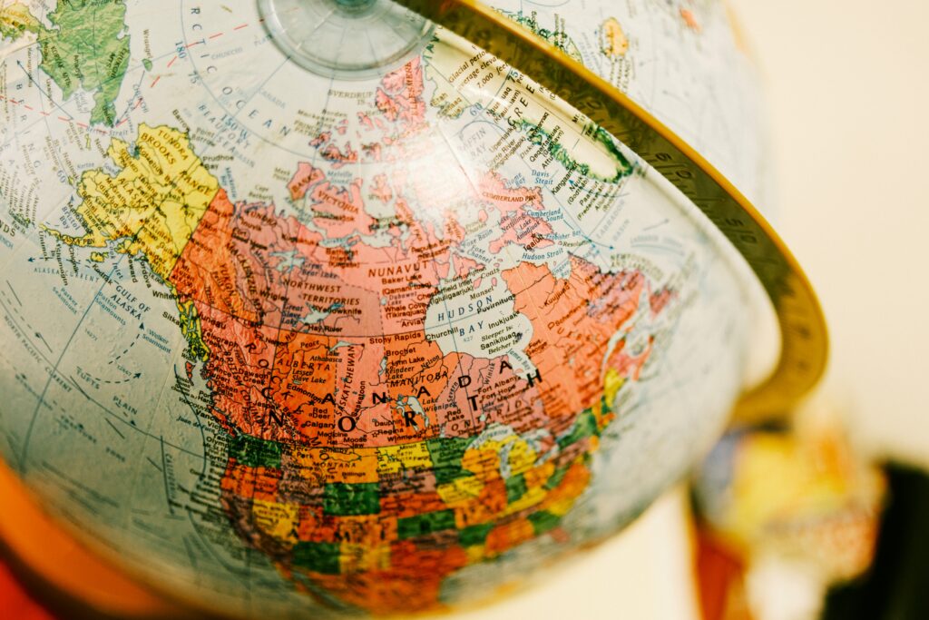 A detailed close-up of a globe highlighting Canada and its provinces, representing the journey of immigrating to Canadian provinces and understanding regional differences across the country.